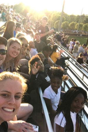 Students and children watch a game